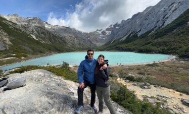 Pareja disfrutando de la Laguna Esmeralda en Ushuaia, rodeados de montañas y naturaleza, en una excursión con XPLOR TURISMO