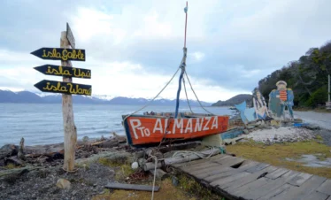 Cartel de bienvenida artesanal en Puerto Almanza con vista al Canal Beagle e islas cercanas.