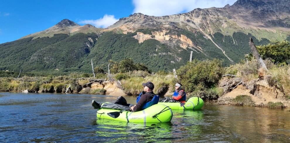 Personas haciendo packrafting en el Río Olivia rodeados de montañas y naturaleza en Tierra del Fuego con Xplor Turismo.