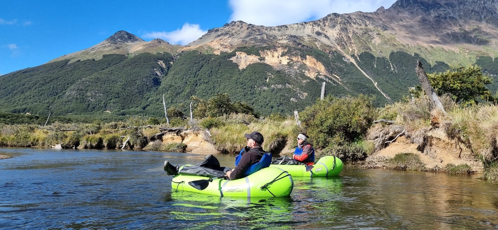 Personas haciendo packrafting en el Río Olivia rodeados de montañas y naturaleza en Tierra del Fuego con Xplor Turismo.
